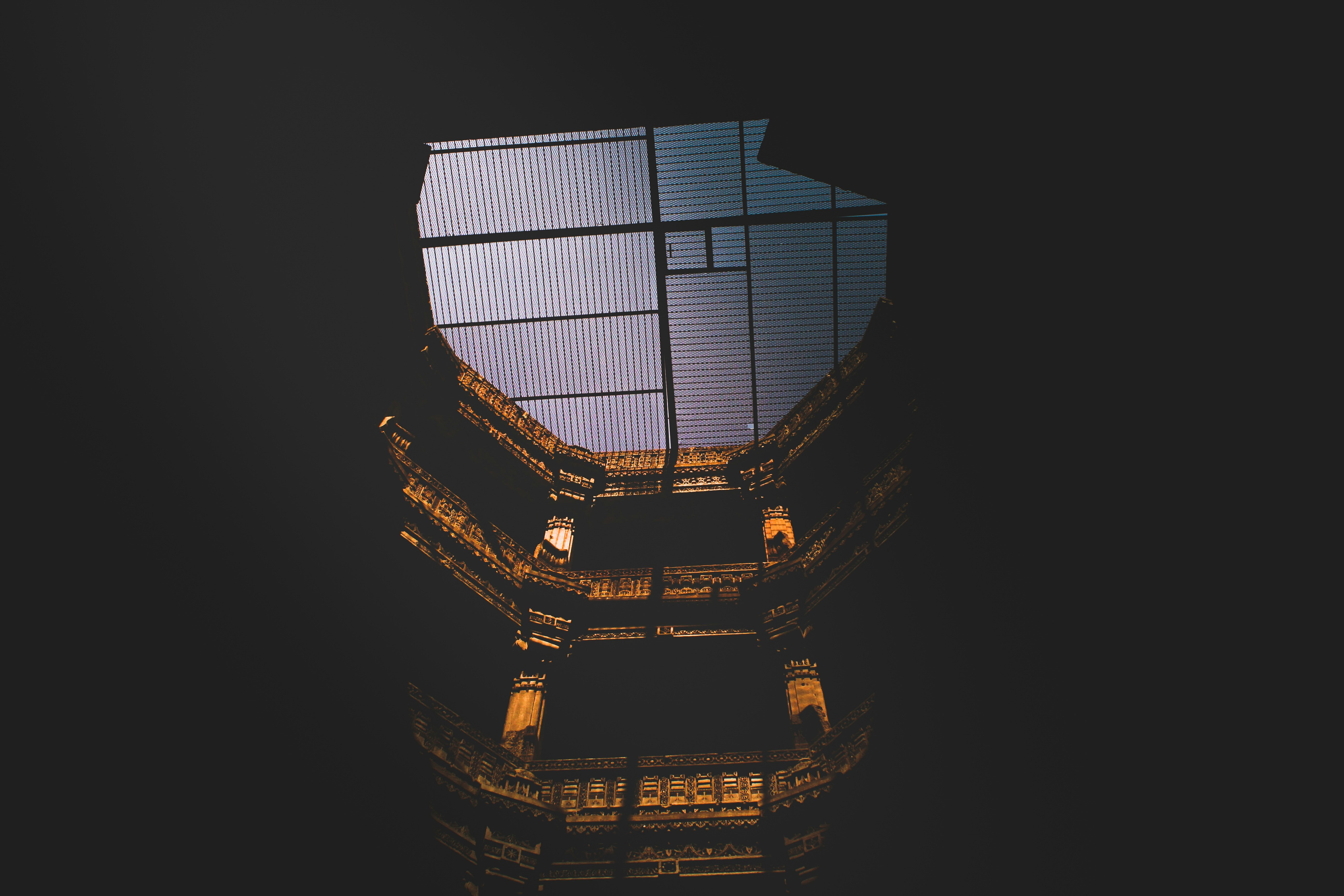 Looking up through the Adalaj Stepwell at a gray sky